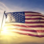 United States american usa us flag textile cloth fabric waving on the top sunrise mist fog stock photo
