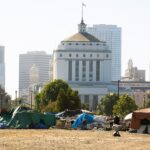 A,Homeless,Encampment,Frames,The,Skyline,Of,Downtown,Oakland,,California,