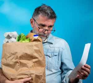 Surprised,Mature,Man,Looking,At,Store,Receipt,After,Shopping,,Holding