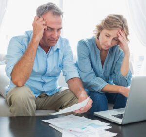 Worried,Couple,Paying,Their,Bills,Online,With,Laptop,At,Home