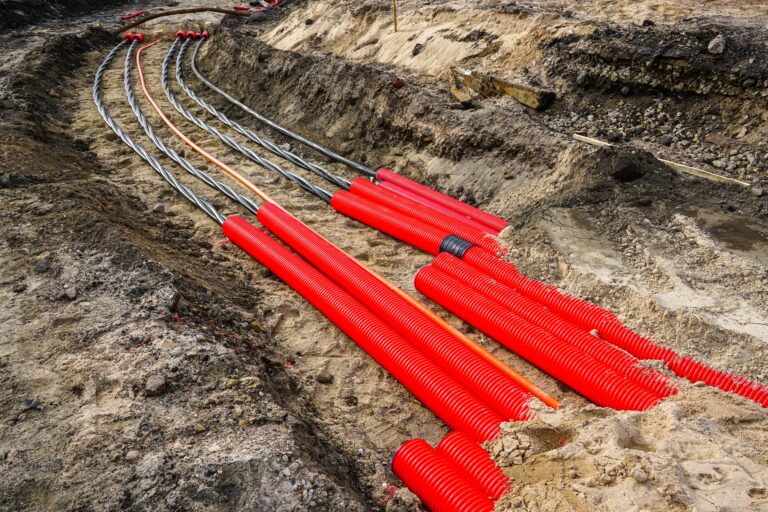 Laying,A,New,Underground,High voltage,Power,Cable,In,Red,Corrugated