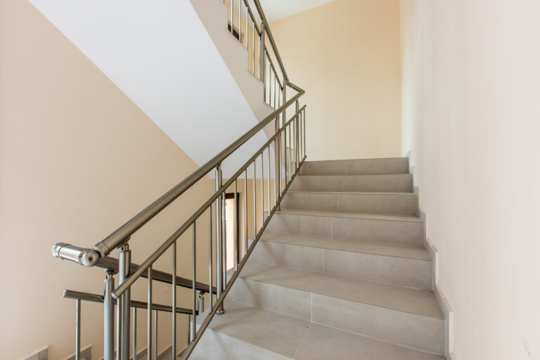 Modern stair case between floors. Stairs with metallic rail in modern building