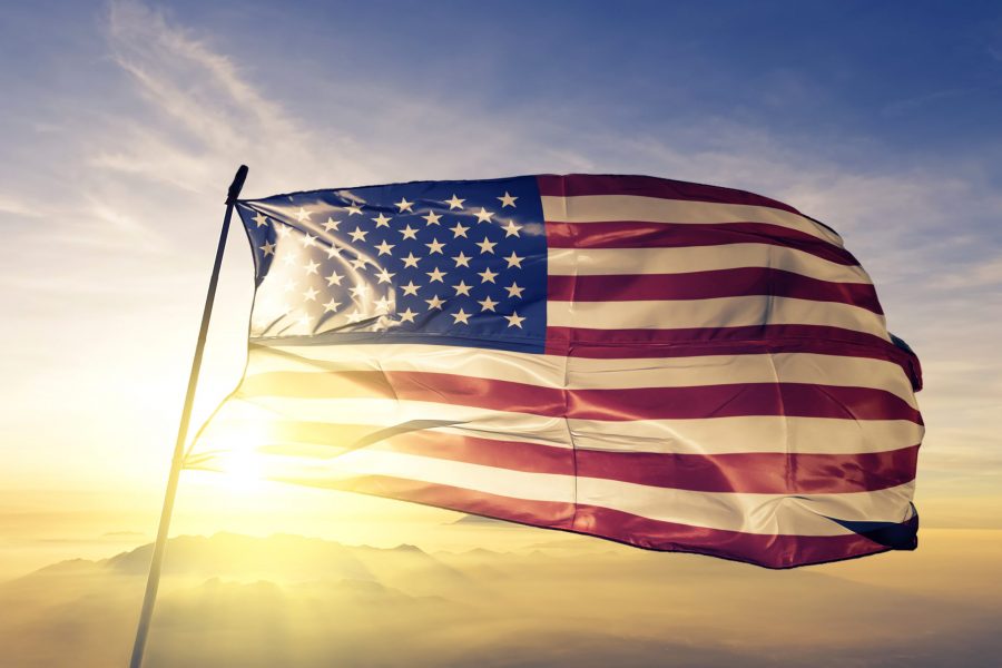 United States american usa us flag textile cloth fabric waving on the top sunrise mist fog stock photo